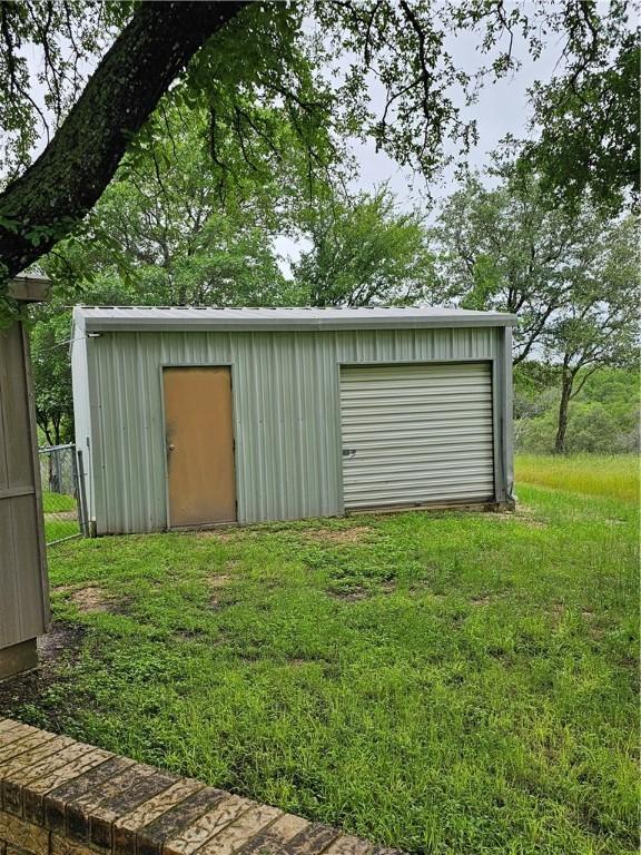 view of outdoor structure featuring a yard and a garage