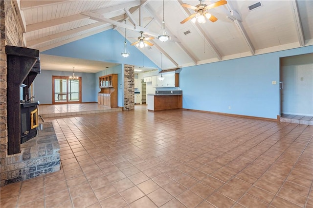 unfurnished living room featuring beam ceiling, ceiling fan with notable chandelier, high vaulted ceiling, and a wood stove