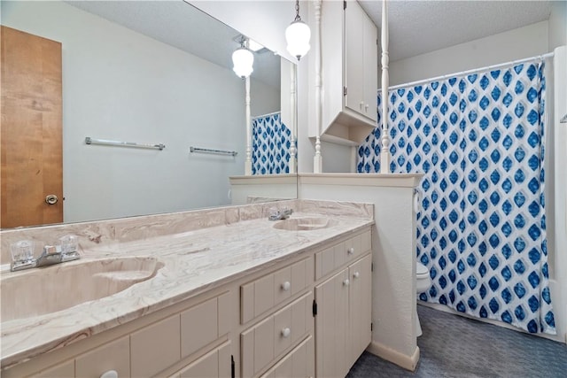 bathroom with a shower with curtain, vanity, toilet, and a textured ceiling