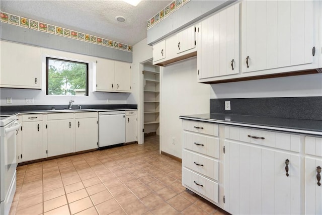 kitchen featuring a textured ceiling, white cabinetry, white appliances, and sink