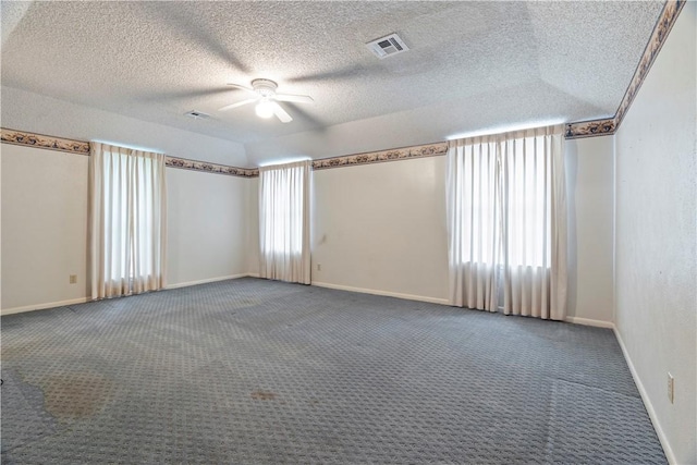 spare room with dark colored carpet, a textured ceiling, and ceiling fan