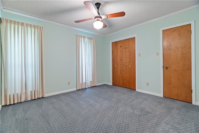 unfurnished bedroom with ceiling fan, dark carpet, crown molding, and a textured ceiling