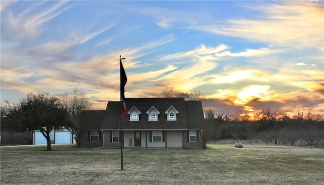 cape cod home with a front lawn