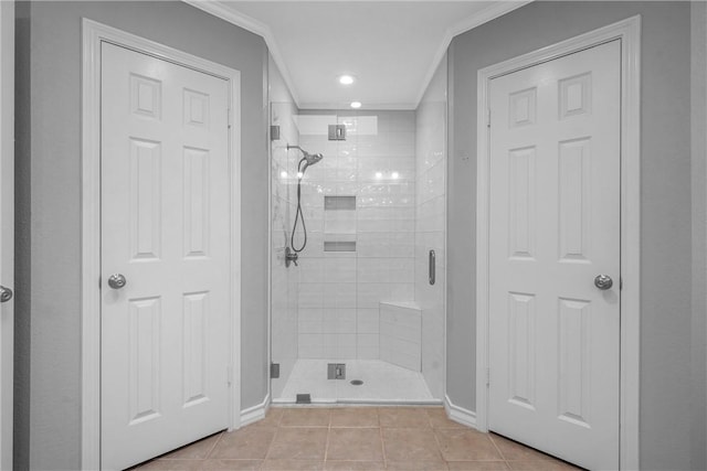 bathroom with crown molding, a shower with shower door, and tile patterned flooring