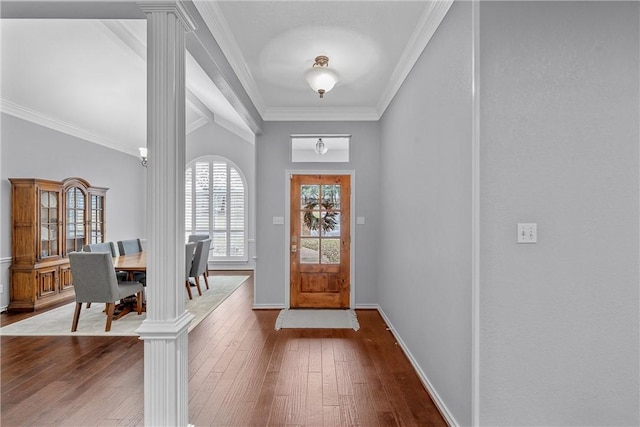 entryway featuring hardwood / wood-style flooring, ornamental molding, and ornate columns