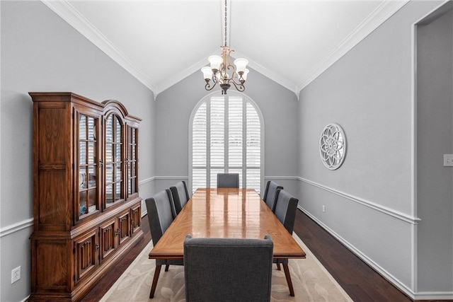 dining space with crown molding, a notable chandelier, hardwood / wood-style flooring, and vaulted ceiling