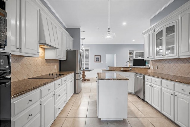 kitchen with decorative light fixtures, kitchen peninsula, white cabinets, and appliances with stainless steel finishes