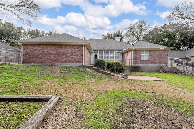 rear view of house featuring a yard