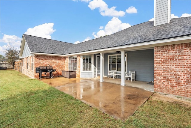 rear view of house featuring a patio area and a lawn