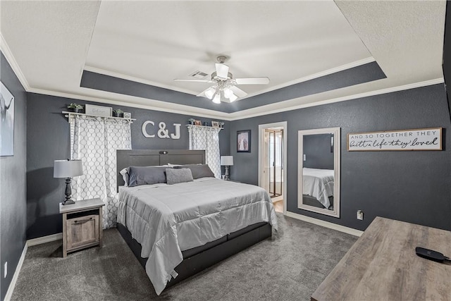 carpeted bedroom with a tray ceiling, ceiling fan, and ornamental molding