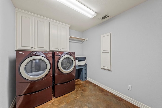 washroom with dark tile patterned flooring, cabinets, and independent washer and dryer