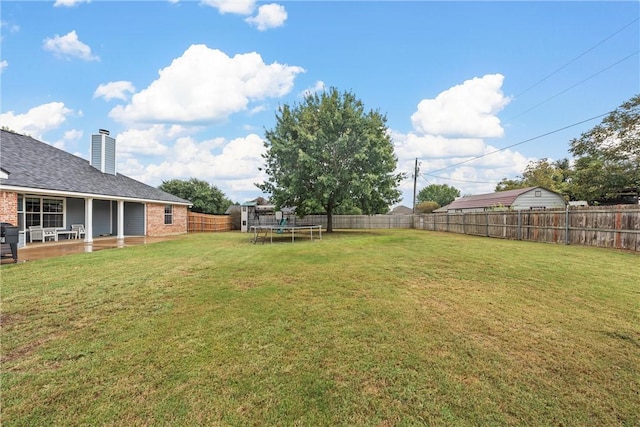 view of yard featuring a trampoline and a patio