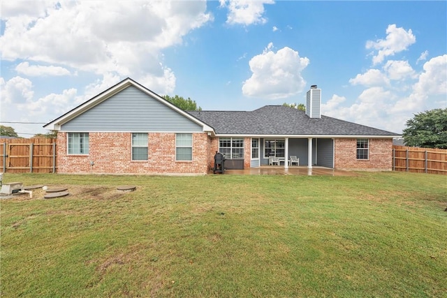 rear view of property with a lawn