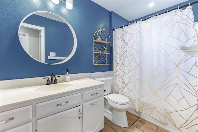 bathroom featuring walk in shower, vanity, toilet, and tile patterned flooring