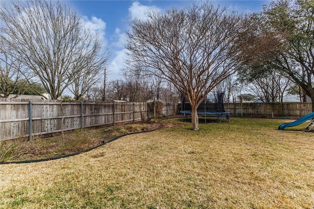 view of yard featuring a playground and a trampoline