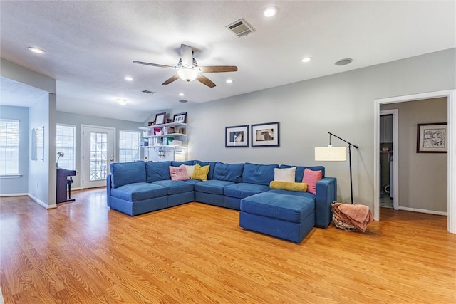 living room with a healthy amount of sunlight, ceiling fan, and light hardwood / wood-style flooring