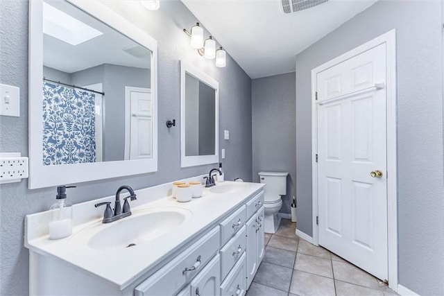 bathroom with tile patterned flooring, vanity, and toilet