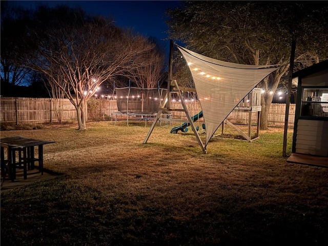 yard at night with a playground and a trampoline