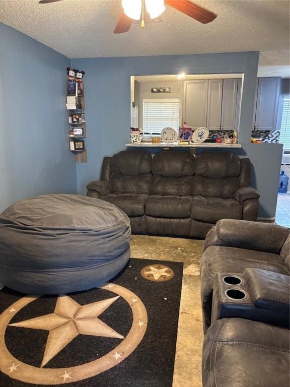 living room with ceiling fan and a textured ceiling