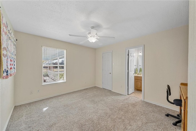 unfurnished office with a textured ceiling, light colored carpet, and ceiling fan