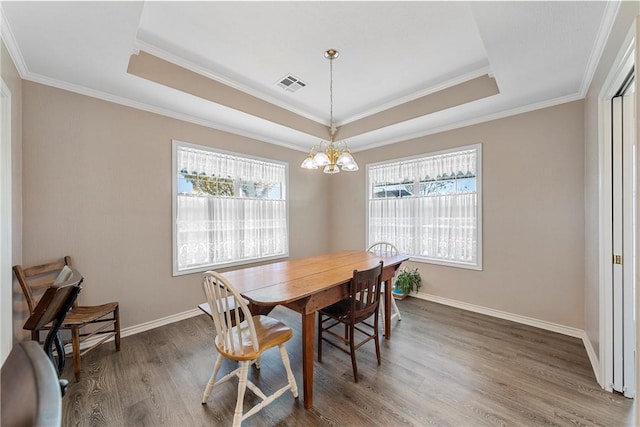 dining area featuring dark hardwood / wood-style flooring, crown molding, and a wealth of natural light