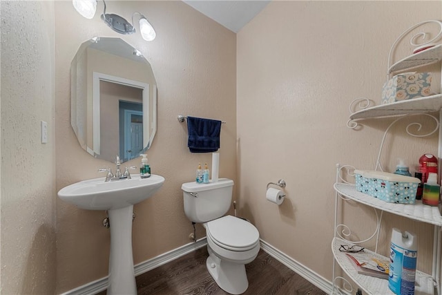 bathroom with sink, wood-type flooring, lofted ceiling, and toilet