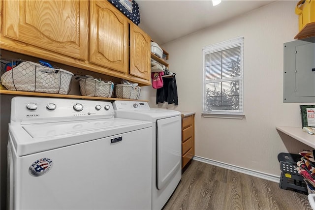 laundry room featuring washer and clothes dryer, dark hardwood / wood-style flooring, cabinets, and electric panel