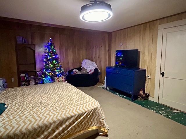 carpeted bedroom with wood walls