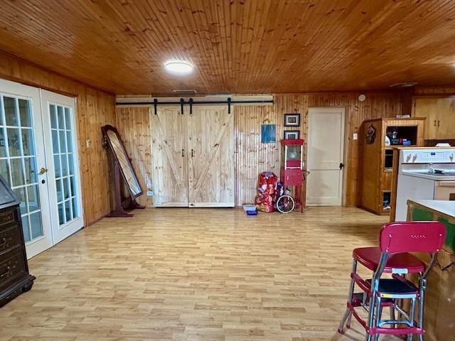 recreation room with french doors, a barn door, wooden ceiling, and wood walls