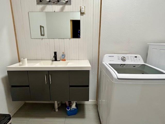 laundry area featuring cabinets, washer / dryer, light tile patterned floors, and sink