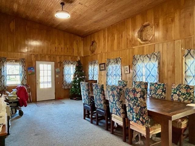 carpeted dining room with wooden walls and wood ceiling