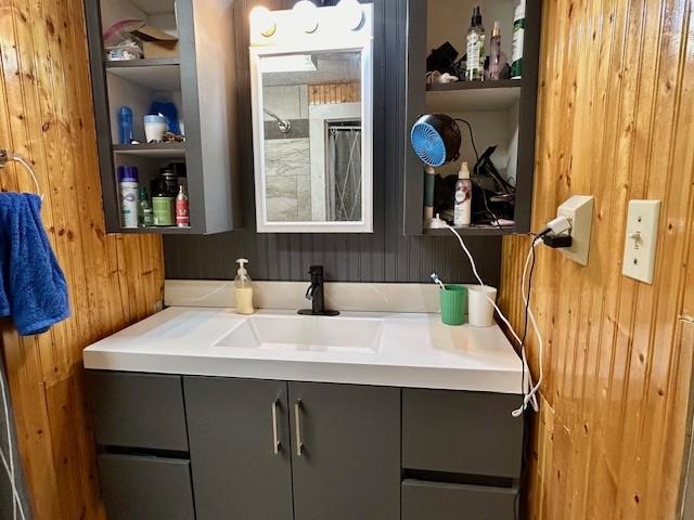 bathroom with wood walls and vanity