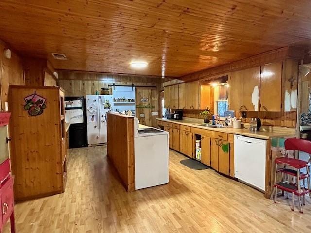 kitchen with white appliances, light hardwood / wood-style floors, wood walls, and wood ceiling