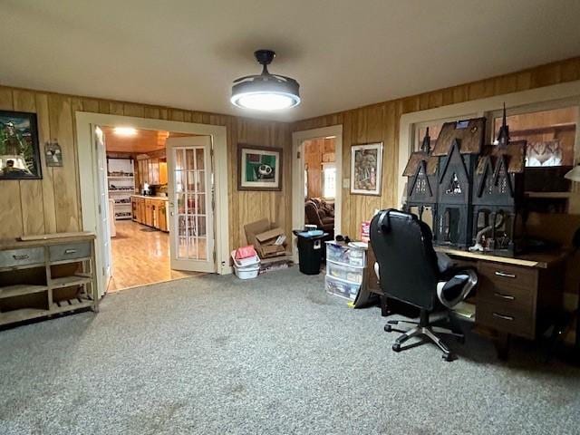 office space with wood walls, light carpet, and french doors