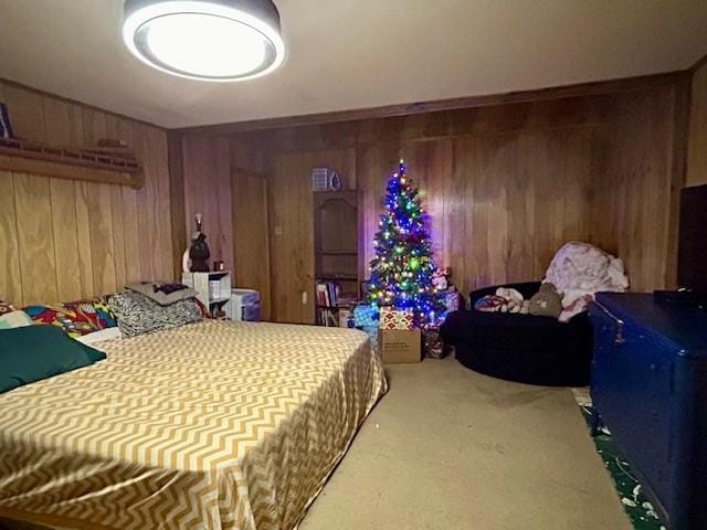 carpeted bedroom featuring wooden walls