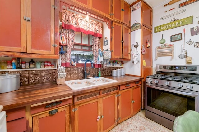 kitchen with stainless steel range with gas cooktop, butcher block counters, and sink