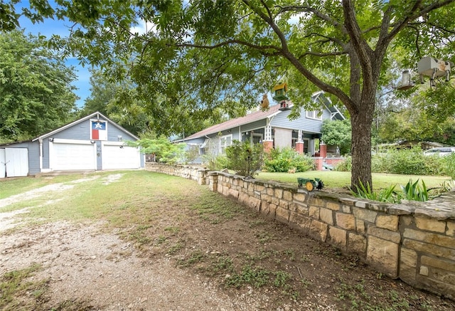 view of yard with a garage and an outbuilding