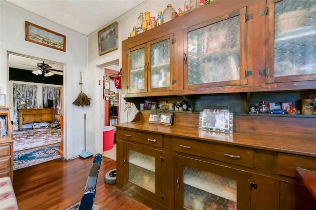 bar with ceiling fan and dark wood-type flooring