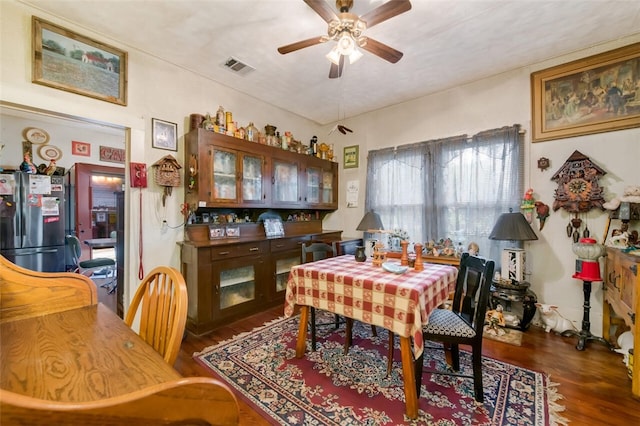 dining area with ceiling fan and dark wood-type flooring