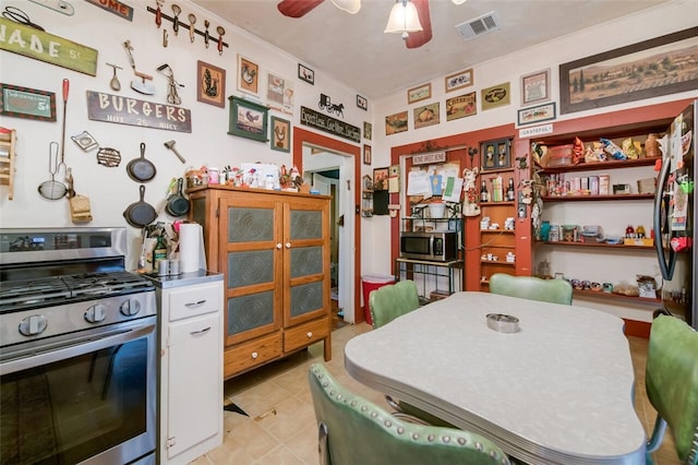 kitchen featuring appliances with stainless steel finishes, ceiling fan, crown molding, white cabinets, and light tile patterned flooring