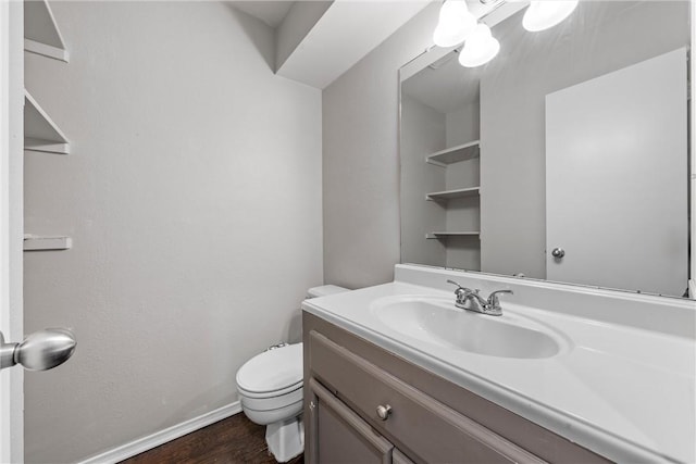 half bathroom featuring baseboards, toilet, wood finished floors, and vanity