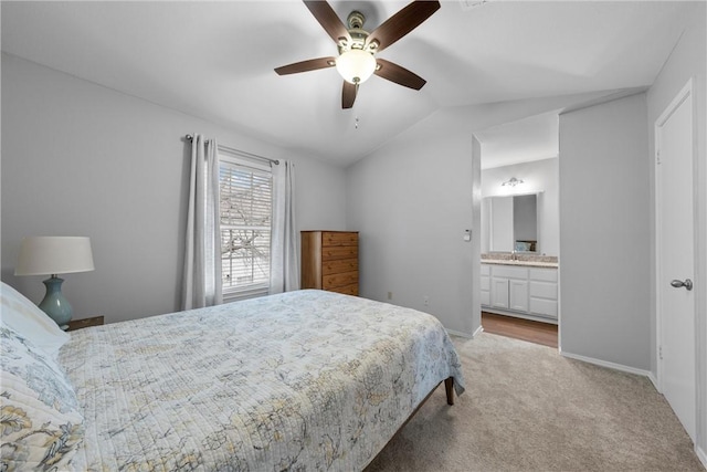 bedroom with connected bathroom, baseboards, light colored carpet, vaulted ceiling, and a ceiling fan