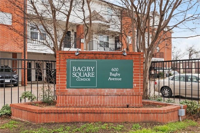 community / neighborhood sign featuring fence