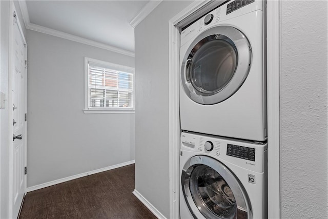 clothes washing area featuring crown molding, laundry area, stacked washer / drying machine, baseboards, and dark wood-style flooring