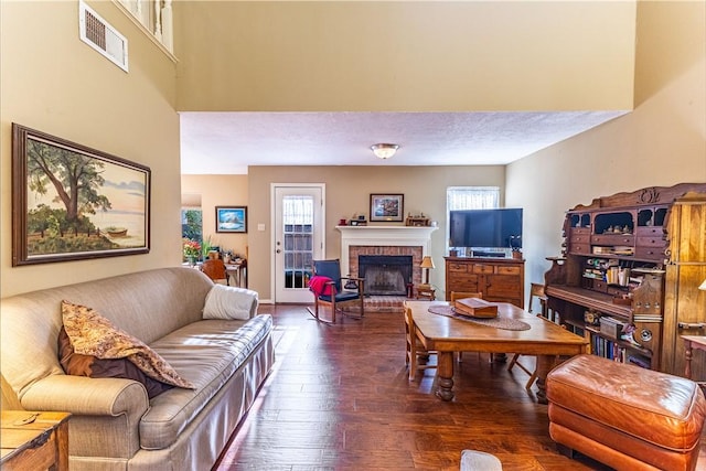 living room featuring a fireplace, plenty of natural light, and dark hardwood / wood-style floors