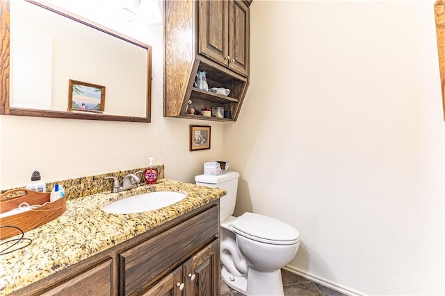 bathroom with toilet, vanity, and tile patterned flooring