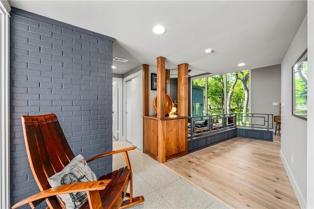 interior space with light hardwood / wood-style floors and brick wall