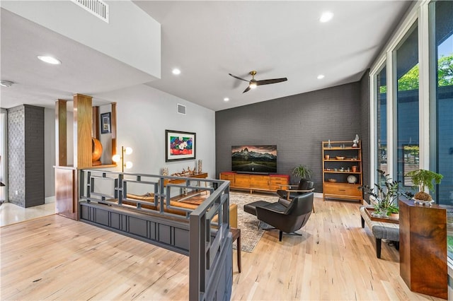 living room featuring light wood-type flooring, vaulted ceiling, and ceiling fan