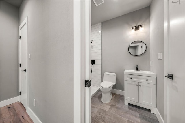 bathroom with vanity, hardwood / wood-style flooring, and toilet