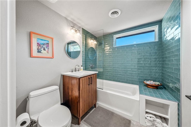 full bathroom with vanity, tiled shower / bath combo, and toilet